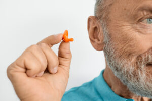 Isolated on white earplug near senior man ear. personally molded earplugs